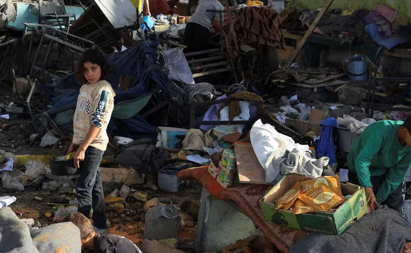 Niños buscan sus cosas entre los escombros de escuela bombardeada en Gaza