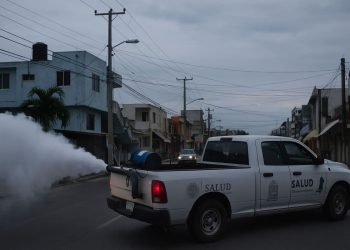 Brigadas de salud realizan nebulización en calles de Cancún para eliminar el mosquito del dengue.