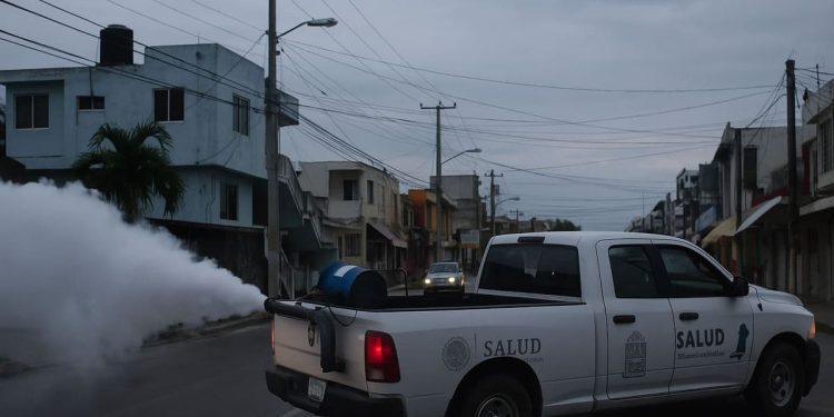 Brigadas de salud realizan nebulización en calles de Cancún para eliminar el mosquito del dengue.