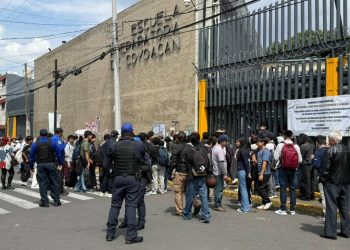 Autoridades y estudiantes afuera de la Prepa 6 de la UNAM tras el desalojo por posible explosivo.