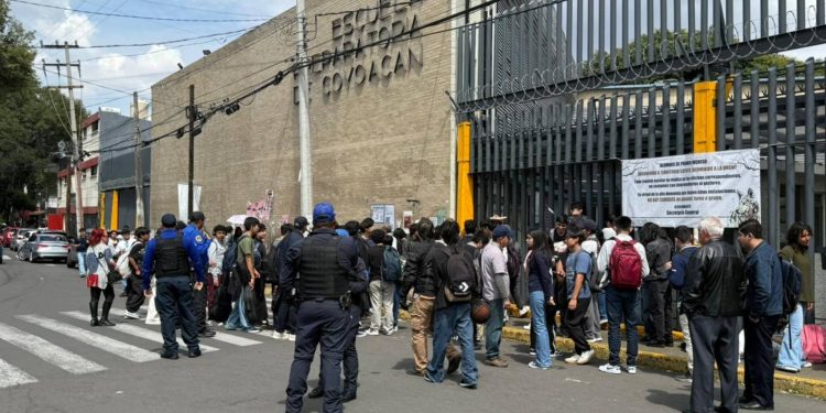 Autoridades y estudiantes afuera de la Prepa 6 de la UNAM tras el desalojo por posible explosivo.