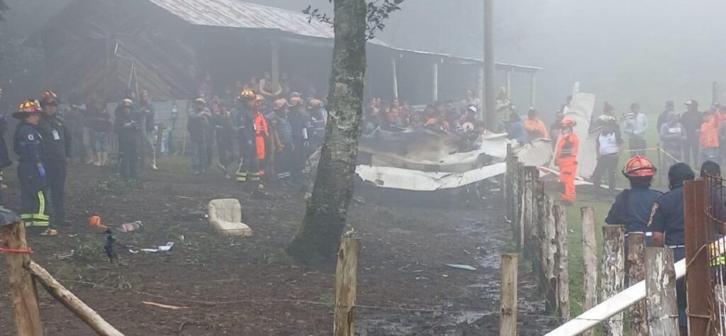 Bomberos y autoridades inspeccionan los restos calcinados de una avioneta en Guatemala.