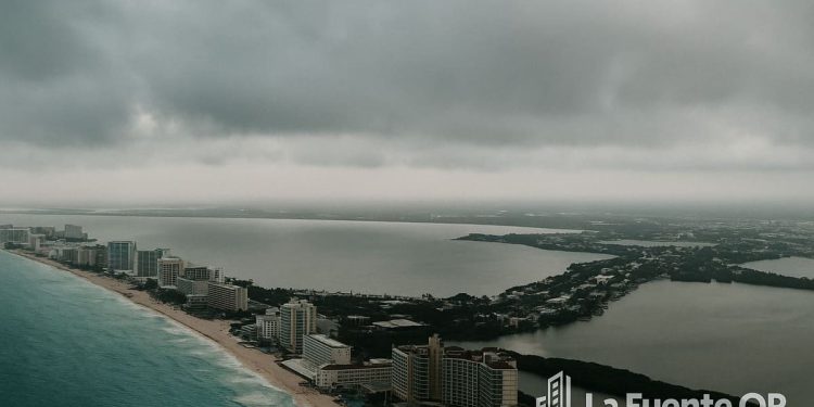 Vista aérea de Cancún con cielo nublado y mar Caribe al fondo, representando el pronóstico de lluvias y ambiente templado en Quintana Roo el 11 de octubre de 2025.