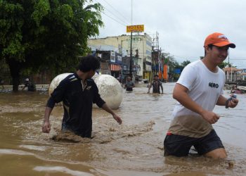 Personas caminan entre el agua tras las inundaciones en Poza Rica, Veracruz, luego del desbordamiento del río Cazones en octubre de 2025.