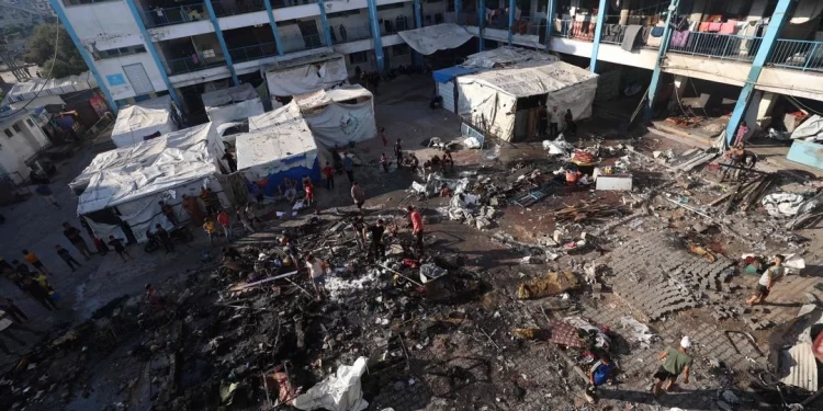 Refugio improvisado en Gaza dañado tras los bombardeos, con civiles inspeccionando el lugar tras el anuncio del alto al fuego por parte de Israel.