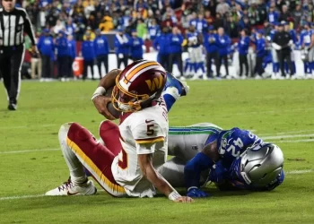 Jayden Daniels sale del campo tras sufrir una lesión en el hombro durante un partido de los Washington Commanders en la NFL 2025.