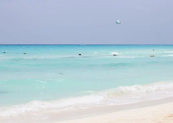 Bañistas en el mar turquesa de una playa pública en Playa del Carmen