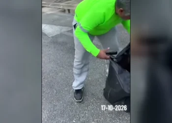 Trabajador de recolección sostiene una bolsa de basura negra en Cancún