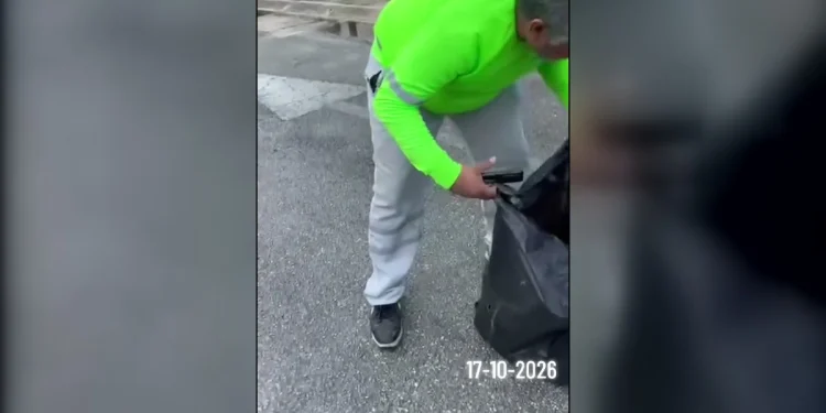 Trabajador de recolección sostiene una bolsa de basura negra en Cancún