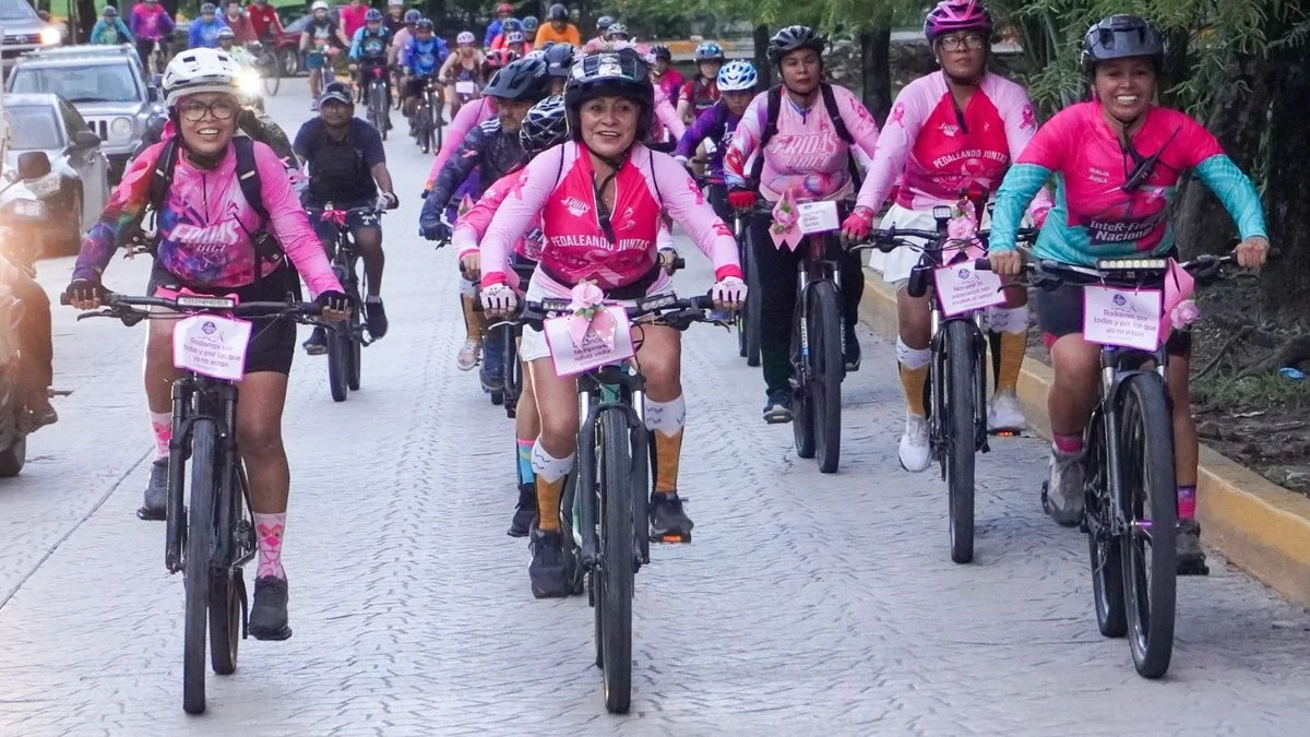 Ciclistas con jerseys rosas durante la rodada contra el cáncer de mama en Cancún